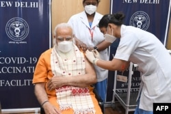 In this photo taken on April 8, 2021, India's Prime Minister Narendra Modi receives the second dose of the Covaxin COVID-19 vaccine, at AIIMS hospital in New Delhi.