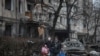 Los residentes locales dejan su edificio de apartamentos, dañado durante un ataque con misiles rusos, en medio del ataque de Rusia a Ucrania, en Kiev, Ucrania, el 13 de diciembre de 2023.