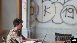 A Polish man works on a laptop in a cafe in Warsaw, Poland, Aug. 1, 2019.