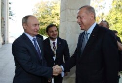 Russian President Vladimir Putin, left, and Turkish President Recep Tayyip Erdogan shake hands before their meeting in the Bocharov Ruchei residence in the Black Sea resort of Sochi, Russia, Oct. 22, 2019.