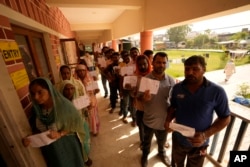 Pakistani Hindu refugees, officially called West Pakistan refugees, who are voting for the first time in any regional election since their migration in 1947, queue up to vote at a polling booth in Ranbir Singh Pura, Jammu and Kashmir, India, Oct.1, 2024.