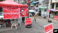 A man walks on a blocked street in an area locked down to curb the spread of the coronavirus, in Yangon, Myanmar, Sept. 11, 2020.