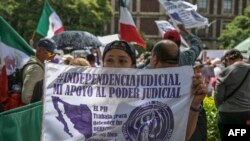 Una mujer sostiene un cartel mientras los empleados del Poder Judicial, que están en huelga indefinida, protestan frente a la Suprema Corte de Justicia de la Ciudad de México, el 25 de agosto de 2024. 