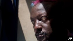 FILE - Prize-winning Kenyan author Binyavanga Wainaina poses for a photograph after giving a television interview in Nairobi, Kenya.