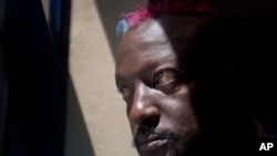 FILE - Prize-winning Kenyan author Binyavanga Wainaina poses for a photograph after giving a television interview in Nairobi, Kenya.