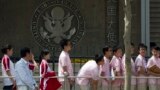 FILE -- In this May 2012 file photo, Chinese students wait outside the U.S. Embassy for their visa application interviews in Beijing, China. 