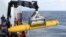 Crew aboard the Australian Defence Vessel Ocean Shield move the U.S. Navy's Bluefin-21 autonomous underwater vehicle into position for deployment in the southern Indian Ocean to look for the missing Malaysia Airlines flight MH370, April 14, 2014.