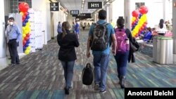 Pasajeros en el Aeropuerto Internacional de Miami, Florida, caminan por la terminal antes de abordar un avión. [Foto: Antoni Belchi/VOA]