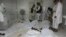 Afghan men stand over the bodies of a suicide bomb blast victims at a hospital in Khost province, June 20, 2012.