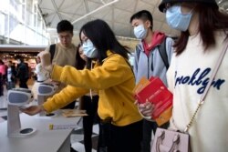 Travelers wearing face masks gather at Hong Kong International Airport in Hong Kong, Jan. 21, 2020.