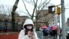 A woman wearing a face mask looks at her phone in Chinatown in the Manhattan borough of New York City, Jan. 25, 2020.