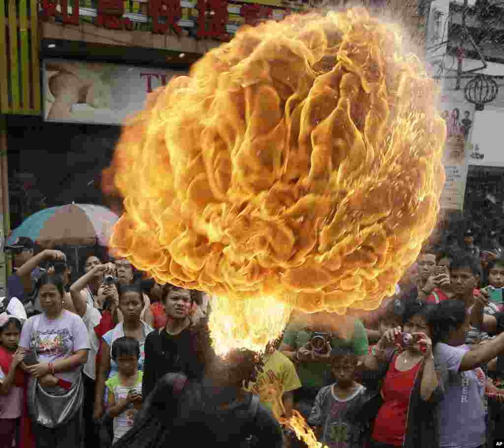 A fire-eater performs in Chinatown to celebrate the Chinese New Year, Manila, Philippines, Feb. 19, 2015.