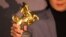 Seorang artis menunjukkan piala Golden Horse (Kuda Emas) dalam ajang penghargaan film 58th Golden Horse Awards di Taipei, Taiwan, Sabtu, 27 November 2021. (Foto: Annabelle Chih/Reuters)