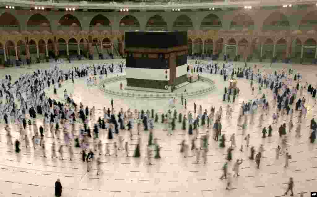 Muslim pilgrims circumambulate the Kaaba, the cubic building at the Grand Mosque, as they wear masks and keep social distancing, a day before the annual hajj pilgrimage in Mecca, Saudi Arabia, July 17, 2021.