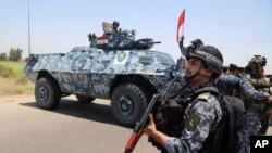 Des militaires irakiens patrouillent dans les rues de Abu Ghraib, à Bagdad le 28 juin 2014.