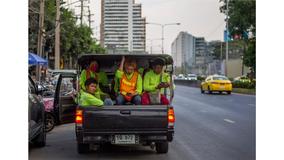 Pekerja konstruksi migran, sebagian mengenakan masker di tengah pandemi corona, berdesakan di dalam truk usai jam kerja di Bangkok, Thailand, 9 April 2020.