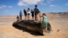 (FILE) People climb on the debris of an Iranian missile intercepted by Israel, near Arad, southern Israel, Oct. 2, 2024. 