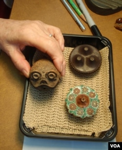 Ceramic opium pipe bowls; the center one has a toad design.(VOA/T. Banse)