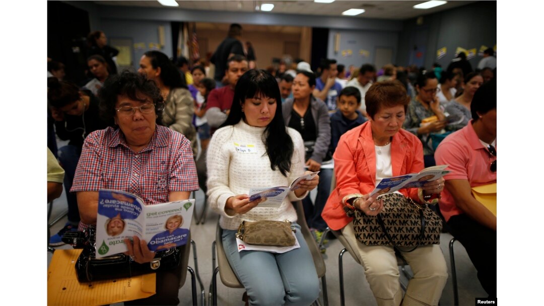 FILE - People wait in line at a health insurance enrollment event in Cudahy, California, March 27, 2014.