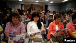 Un grupo de personas participan en un evento para comprar seguro de salud en Cudahy, California. Marzo 27, 2014. 