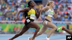 Jamaica's Elaine Thompson, left, and Germany's Gina Luckenkemper compete in a women's 200-meter heat during the athletics competitions of the 2016 Summer Olympics at the Olympic stadium in Rio de Janeiro, Brazil, Aug. 15, 2016. 