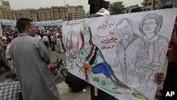 An Egyptian protester carries a banner with drawings depicting ex president Mubarak and reads in Arabic "No forgiveness, our children's blood is not cheap," during a protest at Tahrir Square in Cairo, Egypt, May 27, 2011.