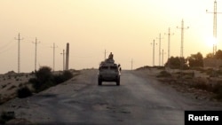 FILE - An Egyptian military vehicle is seen on a highway in northern Sinai, Egypt, May 25, 2015.