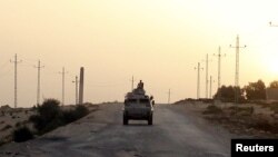 FILE - An Egyptian military vehicle is seen on a highway in northern Sinai, Egypt, May 25, 2015.