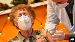 FILE - A resident of a nursing home reacts as she gets an injection of the COVID-19 vaccine in Cologne, Germany, Dec. 27, 2020. 