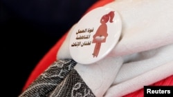 A badge reads "The power of labor aginst FGM" is seen on a volunteer during a conference on International Day of Zero Tolerance for Female Genital Mutilation (FGM) in Cairo, Egypt, Feb. 6, 2018. 