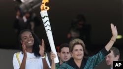 지우마 호세프 브라질 대통령이 그리스를 출발해 3일 브라질리아 대통령 궁으로 옮겨진 올림픽 성화를 들고 있다.