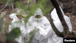 Forensic technicians check charred bones found at a site believed to be a mass grave at an abandoned ranch in the municipality of Garcia, on the outskirts of Monterrey, Mexico, May 31, 2017. Fourteen bodies were found this week in a mass grave near the tourist resort of San Jose del Cabo on the southern tip of the Baja Peninsula, authorities said.
