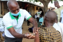 Seorang Muslim diberikan vaksinasi Moderna di luar sebuah masjid di pinggiran Abuja, Nigeria pada 8 Oktober 2021. (Foto: AP)
