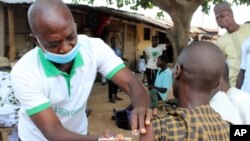 A man is administered a Moderna COVD-19 vaccine outside a mosque on the outskirts of Abuja, Nigeria, Oct. 8, 2021.