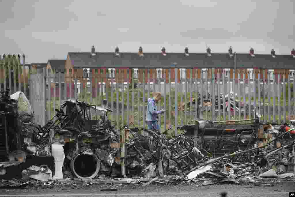 A man walks past a burnt out bus on the Shankill road in West Belfast, Northern Ireland. Authorities sought to restore calm after Protestant and Catholic youths in Belfast hurled bricks, fireworks and gasoline bombs at police and each other.&nbsp;