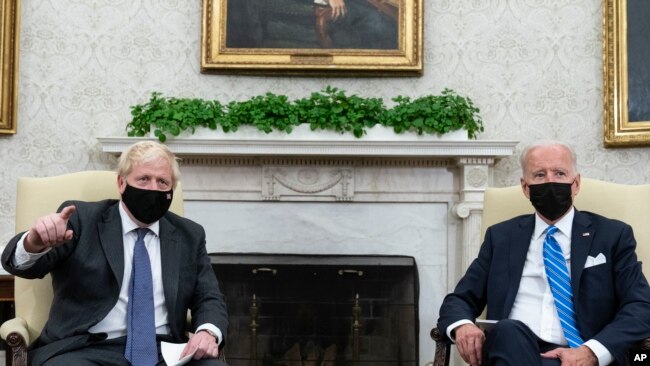 FILE - President Joe Biden, right, listens as British Prime Minister Boris Johnson speaks during a meeting in the Oval Office of the White House, Sept. 21, 2021.