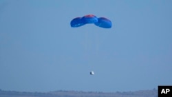 Paracaídas transportan la cápsula de Blue Origin con los pasajeros William Shatner, Chris Boshuizen, Audrey Powers y Glen de Vries hasta el puerto espacial cerca de Van Horn, Texas, el miércoles 13 de octubre de 2021.