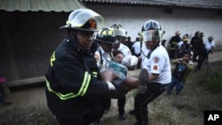 Firefighters carry a woman who fainted outside a reformatory for youth and men, Centro Correccional Etapa II, where a riot and fire broke out in San Jose Pinula, Guatemala, March 19, 2017. 