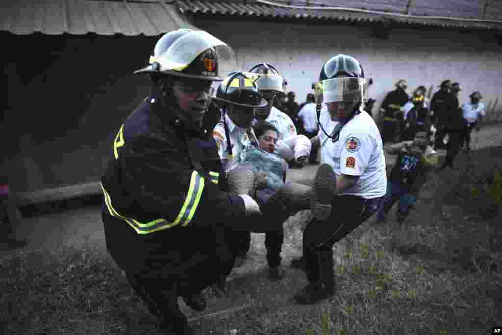 گوئٹے مالا میں فسادات اور آتشزدگی کے دوران ایک خاتون کو طبی امداد کے لئے اسپتال منتقل کیا جا رہا ہے۔