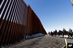 Agentes de la Patrulla Fronteriza viajan a lo largo de una estructura de muro fronterizo recién fortificada, el 26 de octubre de 2018, en Calexico, California.