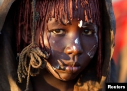 FILE - A Pokot girl, covered in animal skins, walks to a place where she will rest after being circumcised in a tribal ritual in a village about 80 kilometers from the town of Marigat in Baringo County, Oct. 16, 2014.