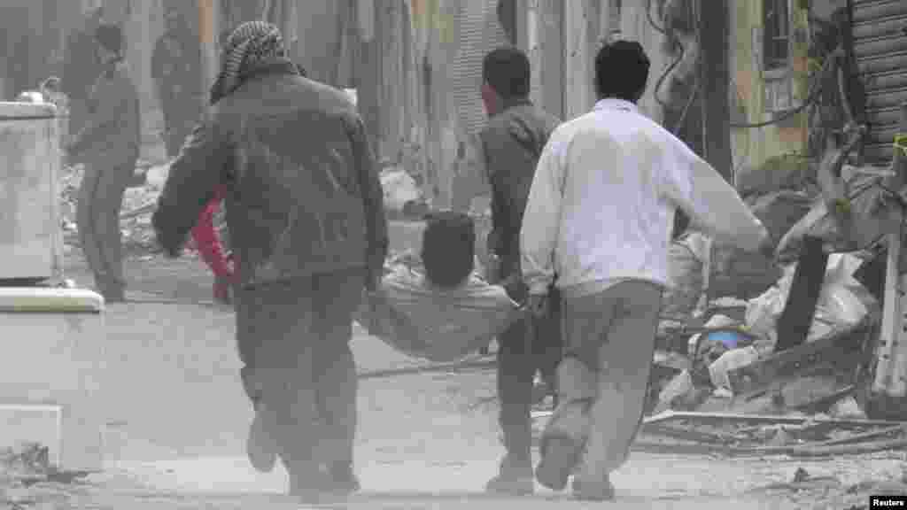People carry a man on a stretcher after he was injured by shelling in the besieged area of Homs, Nov. 25, 2013.