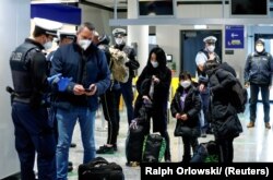 Polisi federal Jerman memeriksa para penumpang dari Inggris yang tiba di Bandara Frankfurt di tengah merebaknya pandemi virus corona, di Frankfurt, Jerman, 30 Januari 2021. (Ralp Orlowski/Reuters)