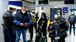 Frankfurt havalimanında polis, yolcuların Corona virüsü testleri ve aşı kartlarını kontrol ediyor.