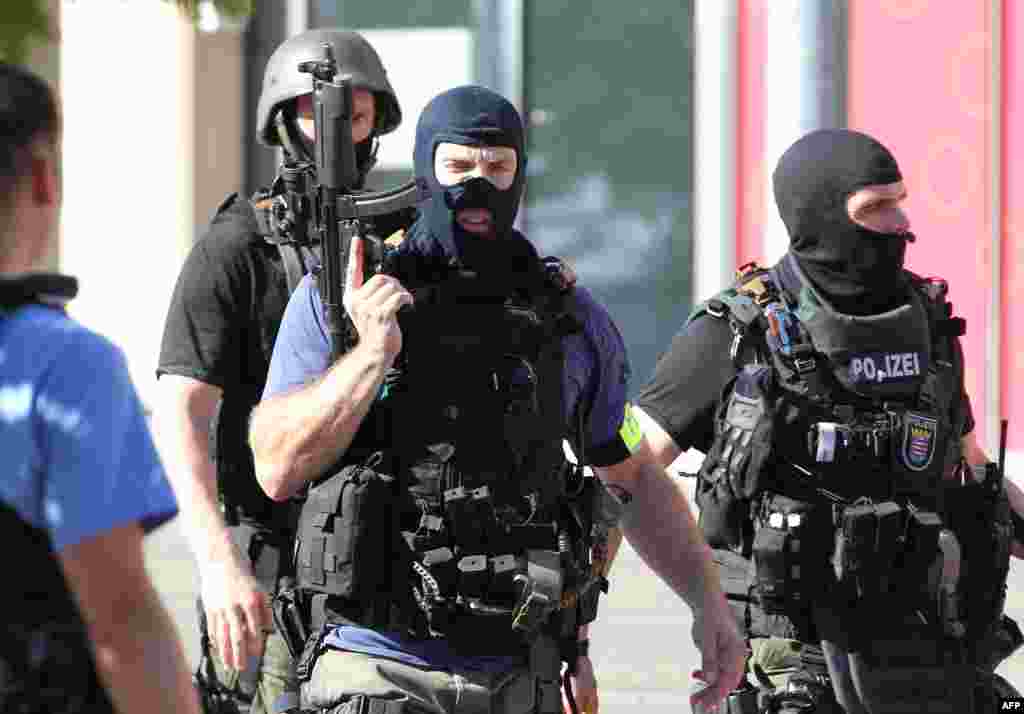 Policemen stand near a cinema where an armed man barricaded himself in Viernheim, southern Germany. Police stormed the Kinopolis shopping complex and shot him dead. Noone was injured.