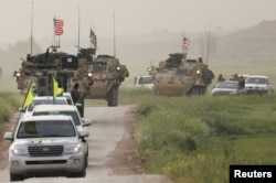 Kurdish fighters from the People's Protection Units (YPG) head a convoy of U.S military vehicles in the town of Darbasiya next to the Turkish border, Syria, April 28, 2017.