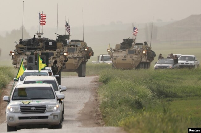 Kurdish fighters from the People's Protection Units (YPG) head a convoy of U.S military vehicles in the town of Darbasiya next to the Turkish border, Syria, April 28, 2017.