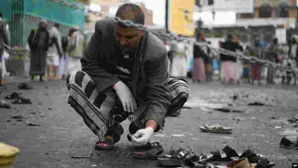 Un agent de sécurité yéménite inspecte le lieu de l&rsquo;attentat suicide à Sanaa, Yémen, jeudi, le 9 ocotbre 2014. AP Photo. 