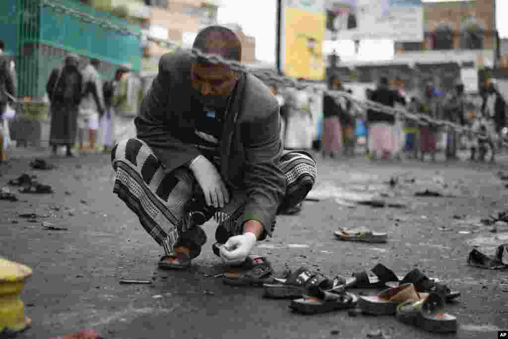 A Yemeni security official inspects objects near the site of a suicide bombing in Sana&#39;a, Oct. 9, 2014. 