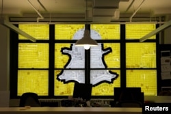 FILE - An image of the Snapchat logo created with Post-it notes is seen in lower Manhattan, New York, May 18, 2016.